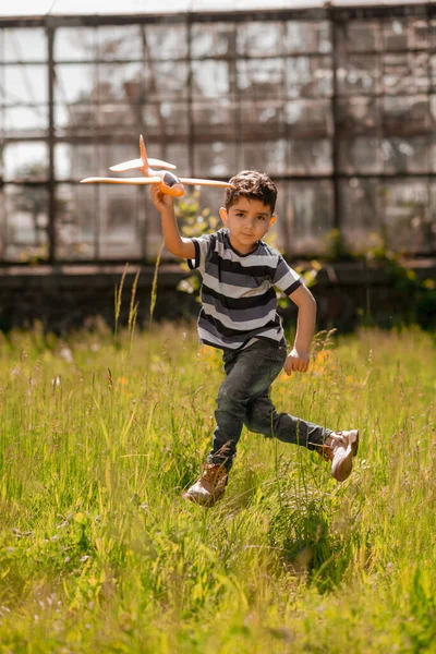Brincar Rapaz Bonito Com Avião Brinquedo Olhando Brincalhão — Fotografia de Stock