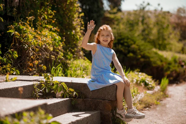 Miúda Gira Uma Menina Bonita Gengibre Vestido Azul Sentado Parque — Fotografia de Stock