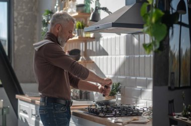 Kahvaltı hazırlıyorum. Adam mutfakta bir şeyler pişiriyor.