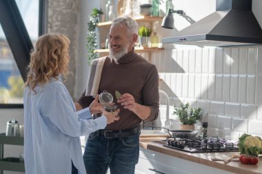 Kahvaltı hazırlıyorum. Mutfakta birlikte yemek pişiren olgun bir çift.