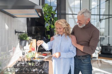 Huzurlu bir sabah. Mutfaktaki olgun çift mutlu ve huzurlu görünüyor.