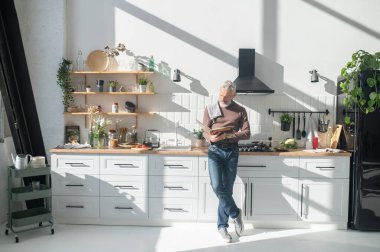 Resepsiyon aranıyor. Sakallı, olgun bir adam yemek kitabında resepsiyon arıyor.