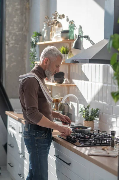 stock image Cooking. Man standing near the stove and frying something