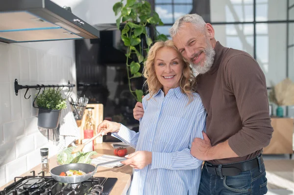 stock image Peaceful morning. Mature couple in the kitchen looking happy and peaceful