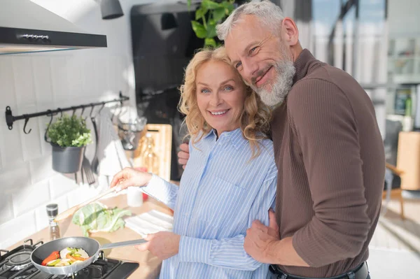 stock image Peaceful morning. Mature couple in the kitchen looking happy and peaceful