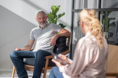 Sohbet. Sarışın bir kadınla konuşan ve ilgili görünen bir adam.