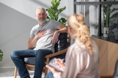 Psikologa. Erkek müşteri bir kadın psikologla konuşuyor.