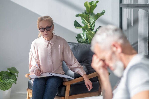 Job loss. . Mature amn looking stressed while having a conversation with a psychilogist