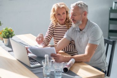Work from home. Two people at the laptop looking involved and discussing something
