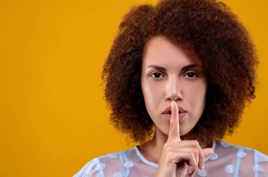 Keep silent. Pretty young woman showing a hush sign