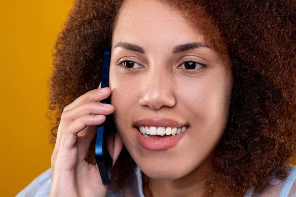 Phone call. Curly-haired young woman talking on the phone