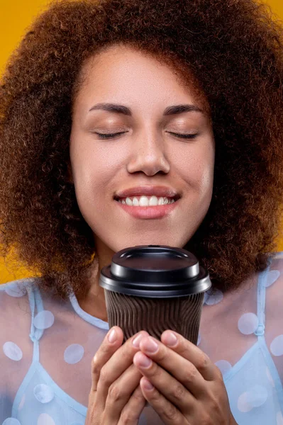 Coffee smell. A smiling pretty woman enjoying coffee smell