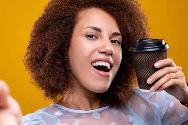 Coffee time. Smiling woman with a cup of coffee in hands