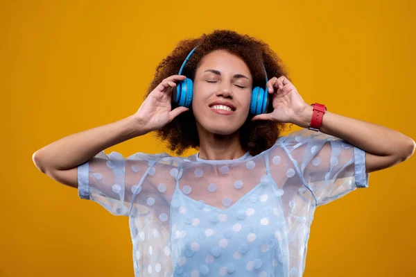 Feeling good. A young woman with headphones looking contented