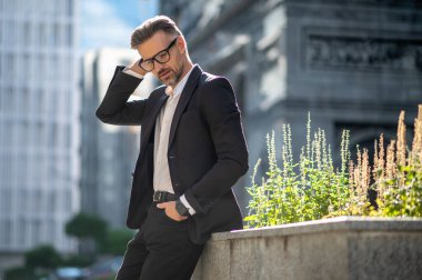 Yakışıklı adammış. Ofis bölgesinde takım elbiseli orta yaşlı yakışıklı bir adam.