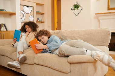 On internet. Two kids spending time at home with devices
