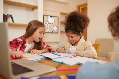 Studying together. Schoolchildren preparing lessons together and discussing the tasks