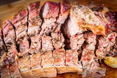 FLANK STEAK beef BBQ food. Roasted meat with potatoes and thyme on a wooden board, completely cut into slices. Close view.