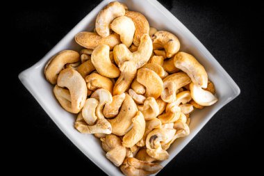 Siyah arka planda çanak çömlekte kaju fıstığı. Üst görünüm.