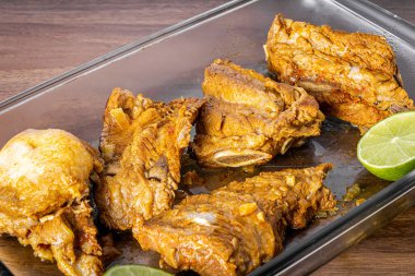 Domuz kaburgaları ahşap bir masada düdüklü tencerede pişirilir..