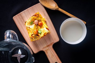 Karıştırıcıda bir parça sosisli börek, tipik Brezilya yemeği. İçindekiler: süt, buğday, yağ, sosis ve mısır. Tahta ve siyah kumaş üzerinde. Üst görünüm.