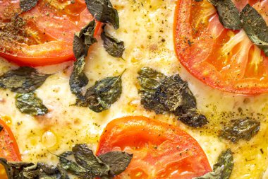 Fesleğenli, sarımsaklı, domatesli, yumurtalı lezzetli margherita pizzası. Siyah arka planda. Yakın görünüm.