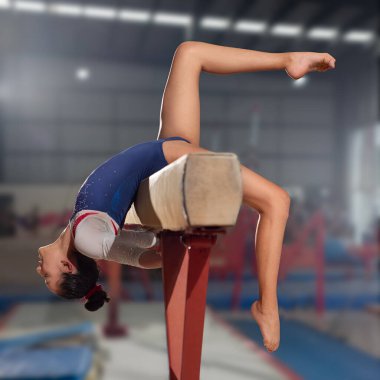 Queretaro, Queretaro, 21 11 11 22 yaşında. Kız spor salonunda denge aletinde sanatsal jimnastik yapıyor.