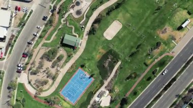 Şehir parkındaki mavi renkli bir basketbol sahasının havadan görünüşü, yeşil bahçeler, dron manzaralı.