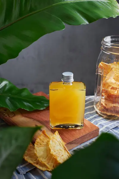 Özel ananas, rom ve mezcal karışımlı cam kavanoz garnitür biber ve ananas bitkileriyle süslenmiş, mutfakta kurutulmuş meyve, insan yok.