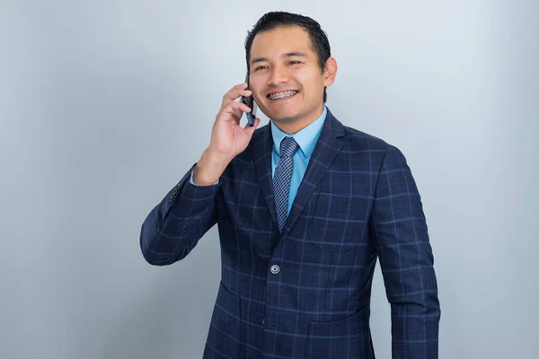 Businessman talks on the phone with a smile on his face, dresses in an entrepreneur's suit, one perso