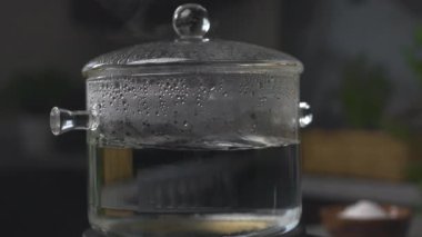 Kahverengi tenli ve kıvırcık saçlı genç bir adam iş yerinde tabletini ve kahvesini evde kullanıyor.