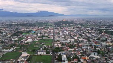 Cholula şehrinin havadan görünüşü, piramit ve kilise uzakta ve arka planda Meksika volkanları görülür.