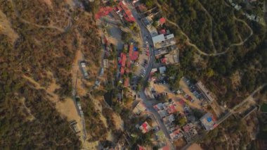 Queretaro Mexico 'daki Bernal kasabasının muhteşem hava manzarası, ormanın içindeki evler turistik bir yerin gecekondu mahallesi gibi, arabaları ve caddeleri olan.