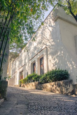 Meksika tarzı büyük bir başkanlık evinin ticari fotoğrafı gün batımında bir kaldırım taşı caddesinde, ağaçlar ve sıcak doğal ışıkla çevrili, mimari, lüks ve huzurlu bir ev atmosferini vurguluyor..