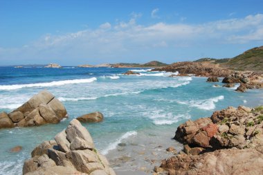 Turkuaz Akdeniz sahilinde dalgalar, kum ve kayalar. Yaz sahnesi