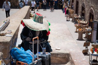 Sokak sanatçısı, canlı renkler ve karmaşık tasarımlar kullanarak geleneksel Fas pazarında fayans boyuyor.