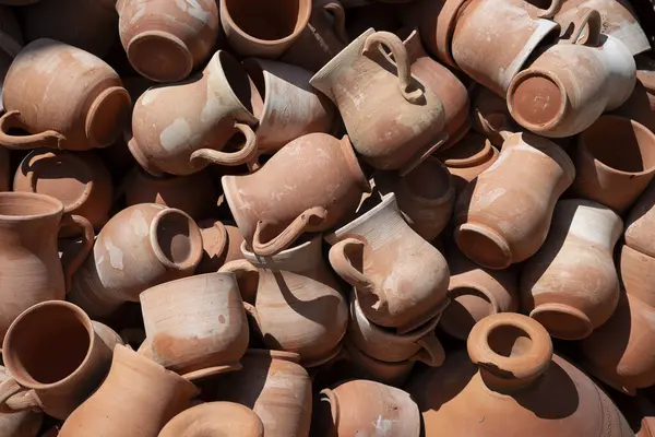 Birçok terracotta tenceresi ve sürahisi bir araya gelerek kırsal ve dünyevi bir görüntü oluşturur.