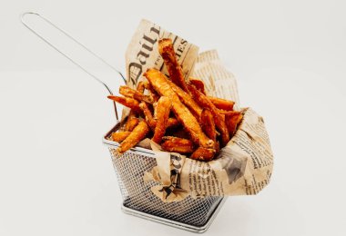 Portion of fried potatoes and sweet potatoes with spicy sauce