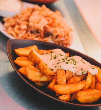 Lokantada tabakta ekşi krema soslu kızarmış patates.