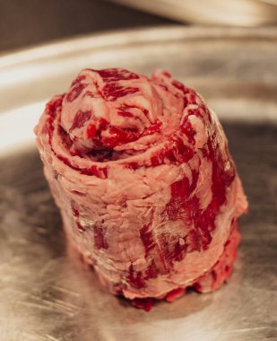 Paslanmaz çelik tabakta çiğ et. Seçici odaklanma. Ayarlanmış.