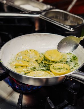Bu fotoğrafta, lezzetli soslu bir tabak ev yapımı İtalyan makarnası görüyoruz. Makarna mükemmel pişmiş ve çok güzel bir altın rengi var. Biraz pürüzlü deseni var..
