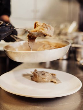 Bu fotoğrafta, lezzetli soslu bir tabak ev yapımı İtalyan makarnası görüyoruz. Makarna mükemmel pişmiş ve çok güzel bir altın rengi var. Biraz pürüzlü deseni var..