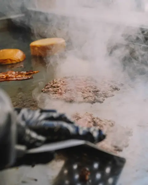 stock image 100% beef burgers on the griddle in a cafeteria