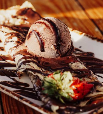 Lezzetli fındık ve çikolata soslu krep, yanında da bir kepçe dondurma.