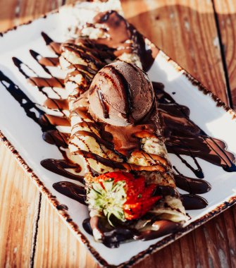 Lezzetli fındık ve çikolata soslu krep, yanında da bir kepçe dondurma.