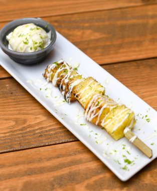 Vanilyalı dondurmalı ızgara ananas şişi.