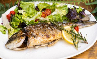 Enfes bir fırınlanmış deniz çipurası ve salata.