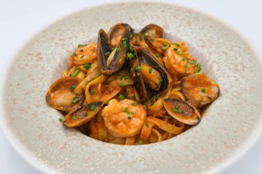 Deniz ürünleri, midye, midye, karides ve domates soslu makarna tabağı..