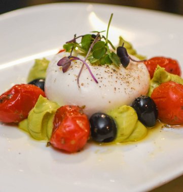 Mozzarella peynirli, zeytinli ve domatesli Caprese salatası