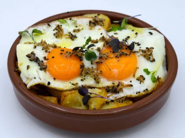 Fried eggs with potatoes on a white background clipart